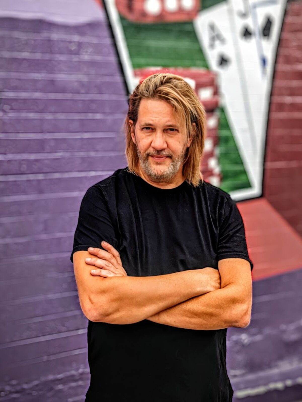 V, Las Vegas close-up magician, photographed against a playing-card wall